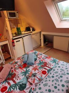 a bedroom with a bed with a flowered blanket at Studio charmant in Fouesnant