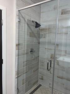 a shower with a glass door in a bathroom at Arthouse in Houston