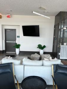 a living room with a couch and a flat screen tv at Arthouse in Houston