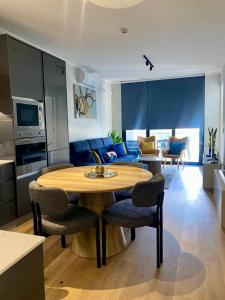 a kitchen and living room with a wooden table and chairs at Elegant-World Ellipse Waterfall in Midrand