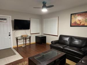 a living room with a leather couch and a flat screen tv at Sunnyside Rental-Entire vacation home 3 Bedroom 2 Bathrooms 1 Kitchen in McHenry