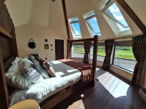a bedroom with a bed in a room with windows at Y Cwlwm - The Celtic Knot in Lampeter