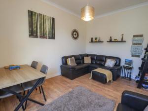 a living room with a leather couch and a table at St Johns View in Keswick