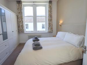 a bedroom with a white bed with towels on it at St Johns View in Keswick