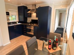 a kitchen with black cabinets and a glass table at Evermore Lodge in Windermere
