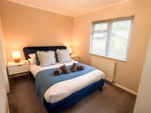 a bedroom with a bed with two teddy bears on it at Evermore Lodge in Windermere