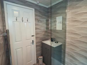 a shower with a glass door and a sink in a bathroom at Evermore Lodge in Windermere +26 photos