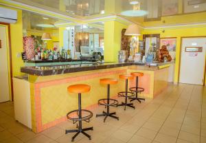 a bar in a restaurant with orange stools at Leet Dorian HOTEL in Libreville
