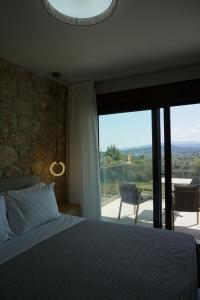 a bedroom with a bed and a large glass window at Aria Vista Chalkidiki in Agios Nikolaos +37 photos