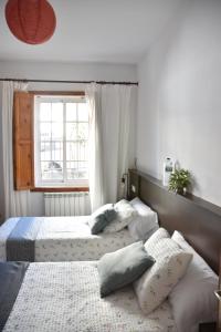two beds in a bedroom with a window at A Casa de Chelo in Palas de Rei