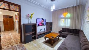 a living room with a couch and a tv at Central Premium Holiday Homes - Marché, Corniche & Océan à pied in Larache