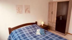 a bedroom with a bed with a blue plaid at Aconchego - com Garagem in Santa Maria