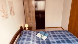 a bedroom with a bed with a blue plaid blanket at Aconchego - com Garagem in Santa Maria