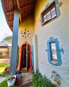 a small house with a red door and a window at The Storybook Nook in Kaapsehoop