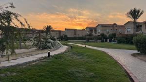 a pathway leading to a house with a sunset in the background at Family-Friendly Chalet at Piacera, Ain Sokhna in Ain Sokhna