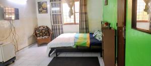 a bedroom with a bed and a chair in a room at Village Tenko in Ouagadougou