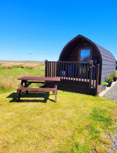 a picnic table and bench in front of a yurt at Ocean View Glamping Pod in Borve