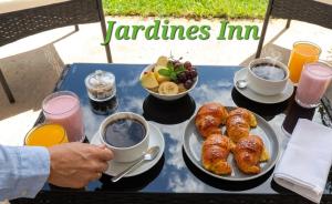 a table topped with plates of pastries and bowls of fruit at Jardines Inn in Trinidad