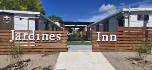 a wooden fence with the words realities inn written on it at Jardines Inn in Trinidad +1 photo