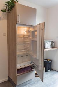 an empty refrigerator with its door open in a kitchen at Ferienwohnung Paradies in Osnabrück