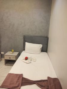 a bedroom with a white bed with a flower on it at Sone Al Boos in Cairo