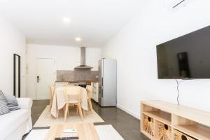 a living room with a table and a kitchen at AG Apartamentos BoiroBello 2 in Boiro
