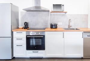 a kitchen with white cabinets and a black oven at AG Apartamentos BoiroBello 2 in Boiro