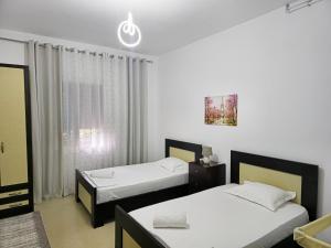 a bedroom with two beds and a window at Villa Llanaj in Berat
