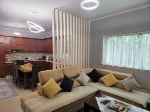 a living room with a couch and a kitchen at Villa Llanaj in Berat