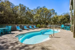 a swimming pool with blue chairs and a fence at 2020 - Merryweather in Sanderling