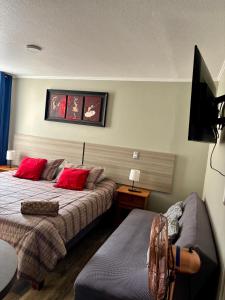 a bedroom with two beds and a flat screen tv at Inversiones Inmobiliarias AYD in Santiago +26 photos