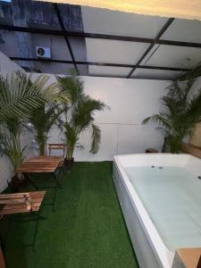 a room with a bath tub and some plants at Jacuzzi Escape Retreat in Kolshet