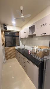 a kitchen with white cabinets and a black counter top at Jacuzzi Escape Retreat in Kolshet