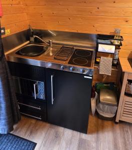 a kitchen with a stove and a sink at Ocean View Glamping Pod in Borve +28 photos