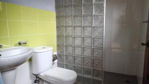 a bathroom with a toilet and a sink and a shower at Kemmiu single room in São Tomé +6 photos