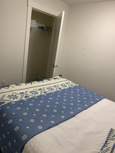 a bedroom with a bed with a blue and white blanket at Gladwin one bedroom in Abbotsford +3 photos