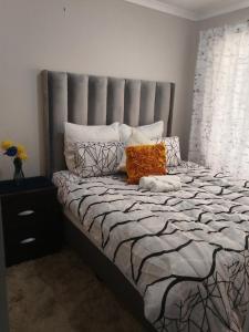 a bedroom with a large bed with orange pillows at Soshanguve Lux Accom Room 02 in Soshanguve
