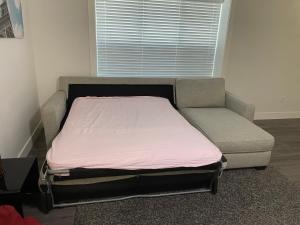 a bed and a chair in a room at Gladwin one bedroom in Abbotsford