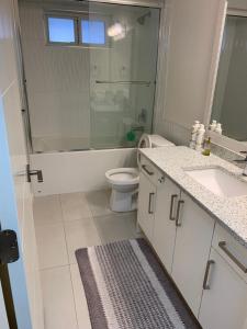 a bathroom with a toilet and a tub and a sink at Gladwin one bedroom in Abbotsford