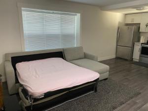 a room with a bed and a couch and a kitchen at Gladwin one bedroom in Abbotsford