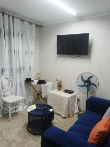 a living room with a blue couch and a tv at Soshanguve Lux Accom Room 02 in Soshanguve +7 photos