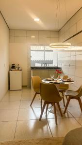 a dining room with a table and chairs in a kitchen at Aurora Serena - Casa com 2 quartos, próximo a rodoviária e aeroporto in Palmas