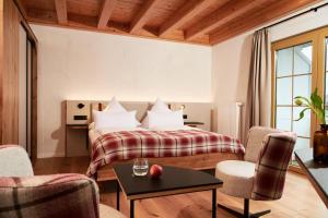 a hotel room with a bed with a table and chairs at Landhotel Haringerhof mit Saunawelt und Naturbadeteich in Grafenhausen +25 photos