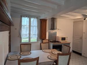 a kitchen with a table with chairs and a microwave at L'escale de Blacourt in Blacourt