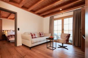 a living room with a couch and a table at Landhotel Haringerhof mit Saunawelt und Naturbadeteich in Grafenhausen