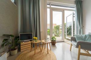 a living room with a tv and a couch and a table at Het arrangement in Wemeldinge