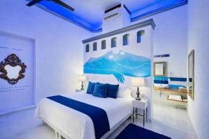 a bedroom with a large white bed with blue pillows at El Sueño Hotel & Spa in Puebla