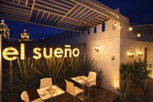 a restaurant with two tables and a sign on the wall at El Sueño Hotel & Spa in Puebla