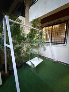 a porch with a swing and palm trees in front of a building at Jacuzzi Escape Retreat in Kolshet