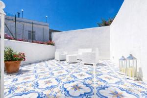 a courtyard with a tile floor with chairs and a building at Fantasy House Suites in Forio d'Ischia